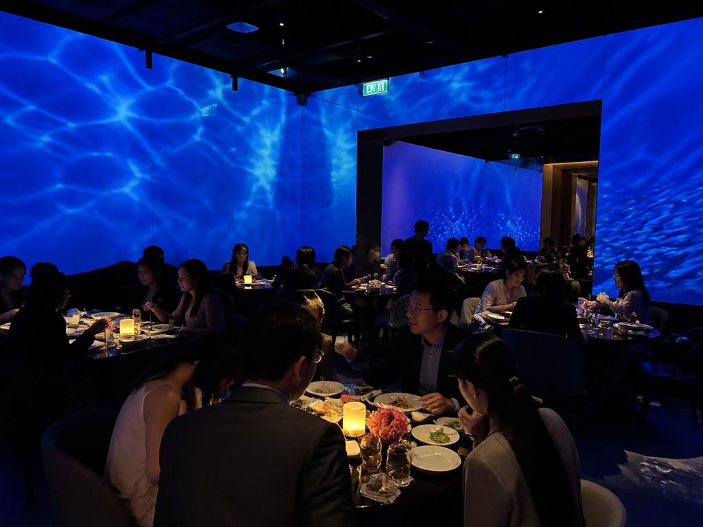 Guests sharing sophisticated seafood dishes at an elegant coastal dinner